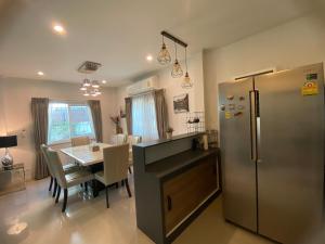 a kitchen and dining room with a stainless steel refrigerator at J&Y Happy Home in Ban Rong