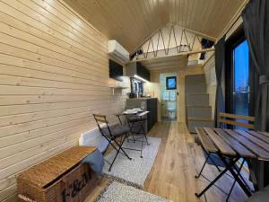 a room with a wooden wall with a table and chairs at Badgers Hollow by Tiny Away in Whitchurch