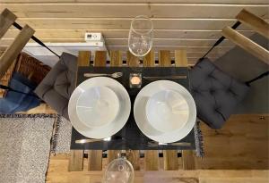a table with two plates and wine glasses on it at Badgers Hollow by Tiny Away in Whitchurch +7 photos