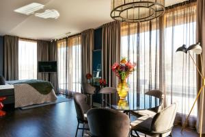 a living room with a table with a vase of flowers at Backstage Hotel Stockholm in Stockholm