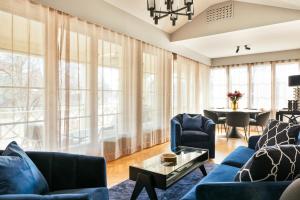 a living room with blue furniture and large windows at Backstage Hotel Stockholm in Stockholm