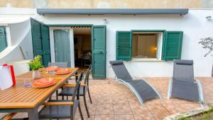 a wooden table and chairs on a patio at Casa CarMa - Relax & Comfort a Cala Gonone in Cala Gonone