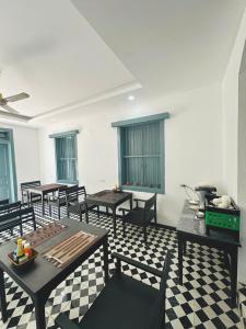 a dining room with tables and chairs and windows at Nagara Premium River View in Luang Prabang