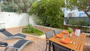 a wooden table and chairs on a patio at Casa CarMa - Relax & Comfort a Cala Gonone in Cala Gonone +18 photos