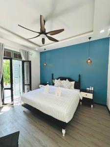 a bedroom with a large bed with a ceiling fan at Nagara Premium River View in Luang Prabang