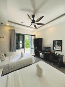 a bedroom with two beds and a ceiling fan at Nagara Premium River View in Luang Prabang