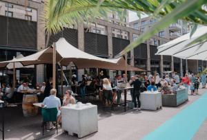 a group of people sitting at tables outside a building at Casa Vista Duna - Kijkduin in The Hague