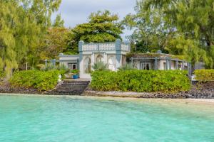 a house on the shore of a body of water at Ile Des Deux Cocos in Blue Bay