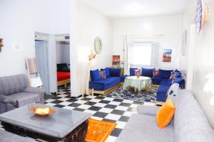 a living room with blue couches and a table at Spacious Apartment with Motorcycle Garage, Free Parking, and Air Conditioning in Er Rachidia