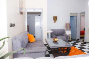 a living room with a couch and a table at Spacious Apartment with Motorcycle Garage, Free Parking, and Air Conditioning in Er Rachidia