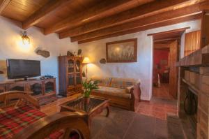 a living room with a couch and a tv at Las Calas de Valleseco in Valleseco