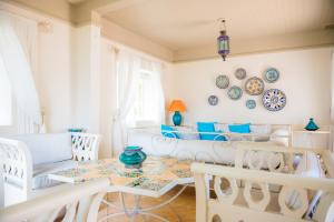 a living room with a table and chairs and plates on the wall at Ile Des Deux Cocos in Blue Bay