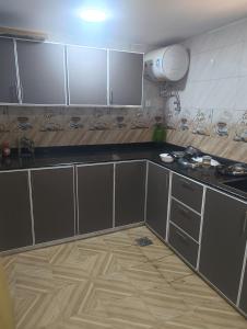 a kitchen with gray cabinets and a wooden floor at Dareen Resort 1 in Bahlāʼ