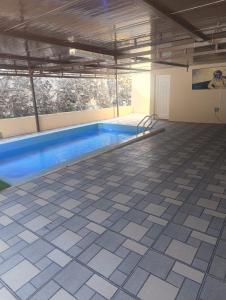 a swimming pool in a building with a bench in it at Dareen Resort 1 in Bahlāʼ