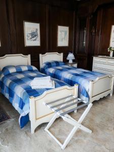 a bedroom with two beds and a chair at B&B Chiara in Limena