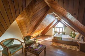 a room with a bed and a chair in a attic at Tripli Hotels Le Royale, Shimla in Shimla