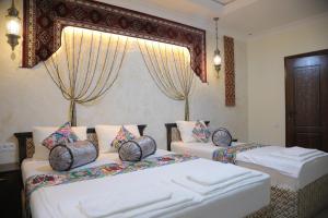 a bedroom with two beds and a window at Oasis al Khiva Boutique Hotel Inside Citadel in Khiva