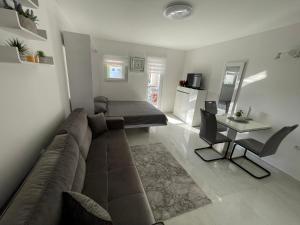a living room with a couch and a table and a bed at Studio apartman Sunset cove in Stinica