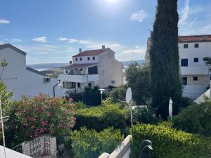 a view of a building with flowers and trees at Studio apartman Sunset cove in Stinica