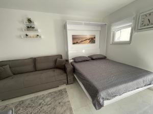 a living room with a bed and a couch at Studio apartman Sunset cove in Stinica