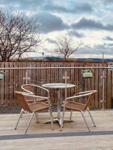 a patio with a table and two chairs and a fence at The Midi Pod in Aberystwyth