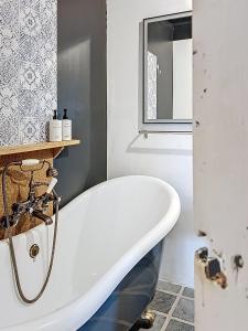 a white bath tub in a bathroom with a window at Le Napoléon in Compiègne +59 photos