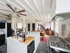 a kitchen with a ceiling fan and a living room at Le Napoléon in Compiègne