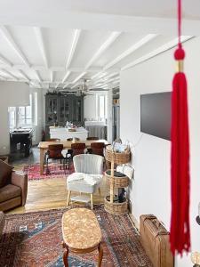 a living room with a couch and a tv on a wall at Le Napoléon in Compiègne