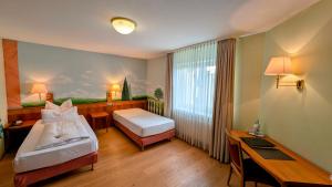 a hotel room with two beds and a desk at Hotel Restaurant Felix in Bensheim +48 photos