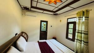a bedroom with two beds and a window at Sigiriya Hidden Home Stay in Sigiriya