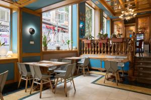 a restaurant with wooden tables and chairs and windows at II Castillas Madrid in Madrid