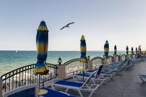 a row of chairs and umbrellas on the beach at Mirage Collective in Nesebar +17 photos