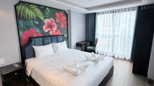a bedroom with a bed with two white flowers on it at Aurora Hotel & Apartment in Hanoi