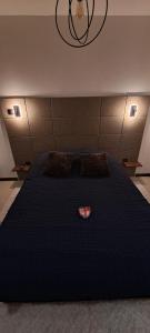 a bedroom with a large black bed with two pillows at Chambre bain balneo indépendante in Valréas