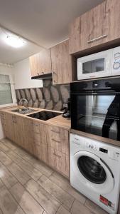 a kitchen with a washing machine and a microwave at Baba néni nyaralója in Szarvas