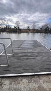 a wooden dock with a chair on top of a lake at Baba néni nyaralója in Szarvas +2 photos