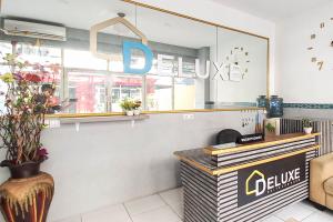 a coffee shop with a sign on the wall at RedDoorz at Deluxe Hotel near Terminal Purabaya Bungurasih in Sidoarjo