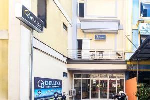 a store front of a building with a motorcycle parked outside at RedDoorz at Deluxe Hotel near Terminal Purabaya Bungurasih in Sidoarjo