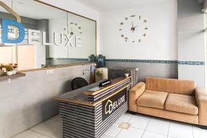 a salon with a chair and a clock on the wall at RedDoorz at Deluxe Hotel near Terminal Purabaya Bungurasih in Sidoarjo
