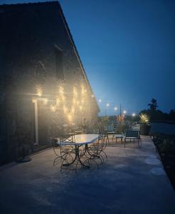 a table and chairs on a patio at night at Gîte de Nath - classé 4 étoiles in Barrais-Bussolles