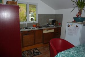 a small kitchen with a sink and a refrigerator at Gite D'étape de roslaye in Gourin