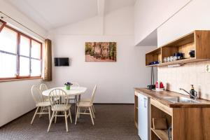 a kitchen and dining room with a table and chairs at K-plus penzión in Štúrovo