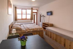 a bedroom with two beds and a table and a tv at K-plus penzión in Štúrovo