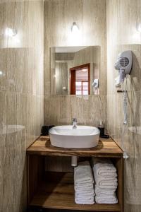 a bathroom with a sink and a mirror and towels at K-plus penzión in Štúrovo +105 photos