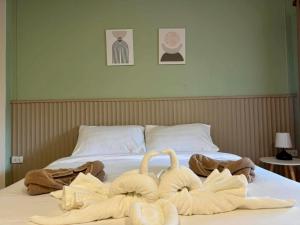 two towel swans sitting on top of a bed at Tree Space Lanta Pool Stay Quiet & Near Beach in Ko Lanta