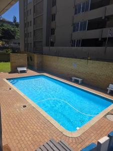 a large blue swimming pool next to a building at Amanzi 1304 in Amanzimtoti