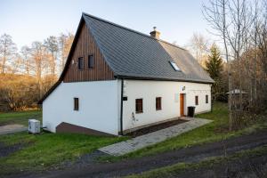 a white barn with a black roof at V Údolí in Jablonné v Podještědí