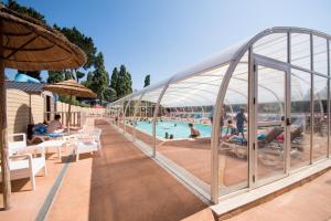 a resort with a swimming pool with people sitting in chairs at Camping Le Panoramic in Binic