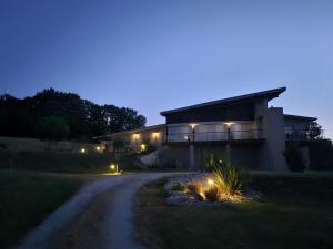 a house with lights on the side of a road at Millésime in Perville