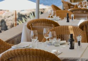 ein Tisch mit Gläsern und Weinflaschen darauf in der Unterkunft Hotel Bendinat in Portals Nous